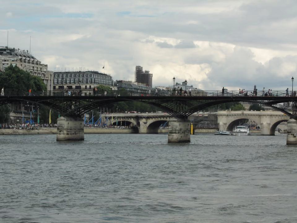 Vista do Rio Sena a partir de um barco de turismo, com a Pont des Arts e a Pont Neuf ao fundo e o casario de Paris na margem