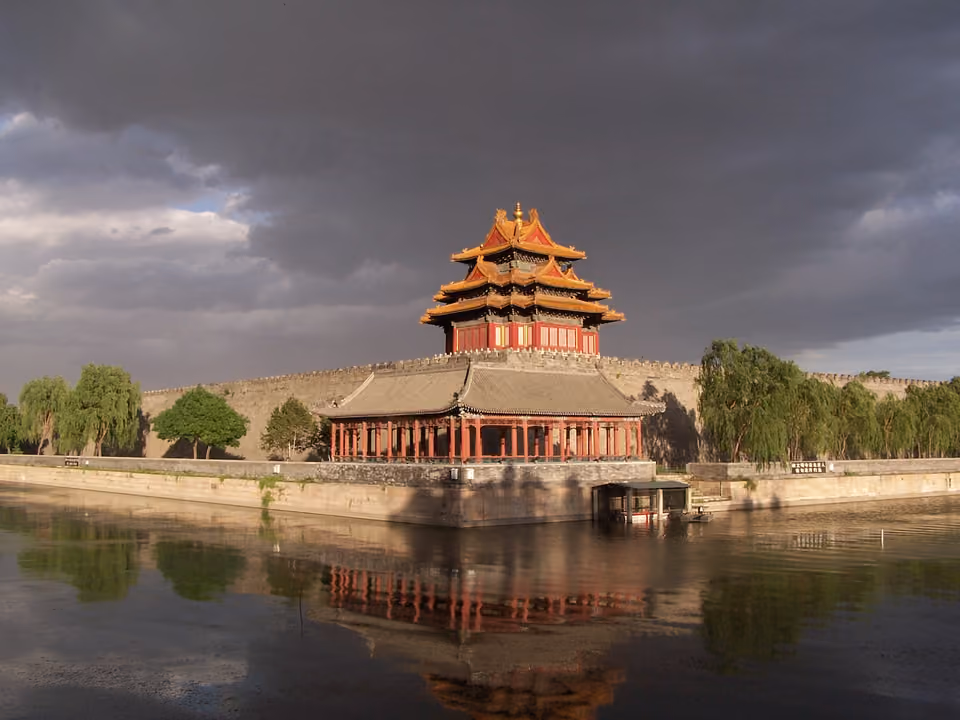 Torre de vigia da Cidade Proibida refletida no fosso ao entardecer, Pequim, China