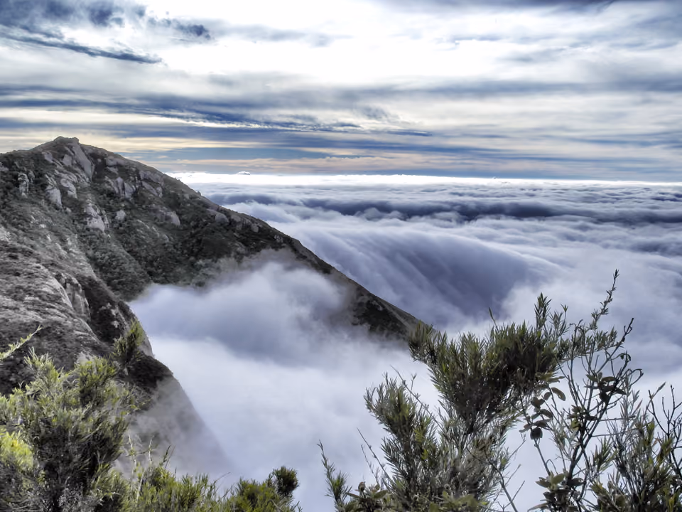 Vista panorâmica do topo da Travessia Petrópolis-Teresópolis, com mar de nuvens sobre o vale