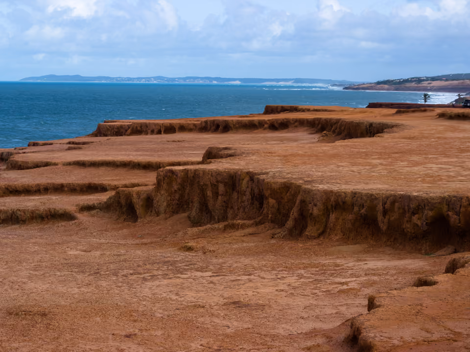 Falésia vermelha e vegetação verde da Praia do Amor, em Pipa
