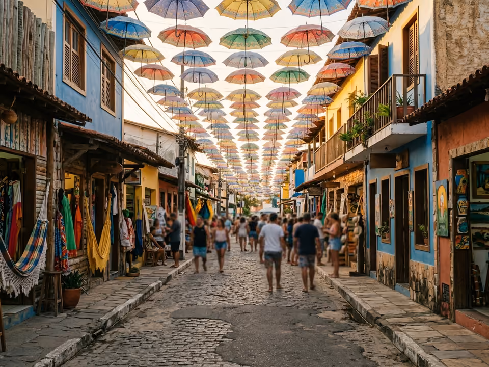 Rua de pedestres da vila coberta por sombrinhas coloridas suspensas, com lojinhas de artesanato