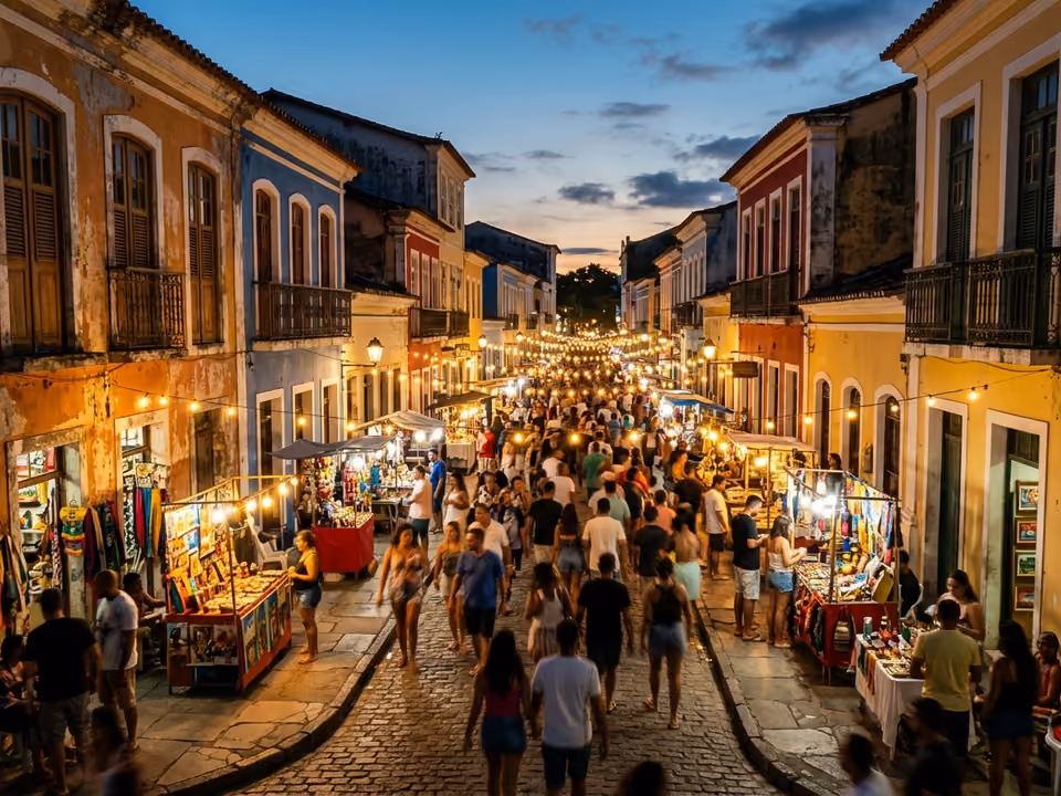 Passarela do Descobrimento ao anoitecer, com casarios coloridos, luzes e barracas de artesanato