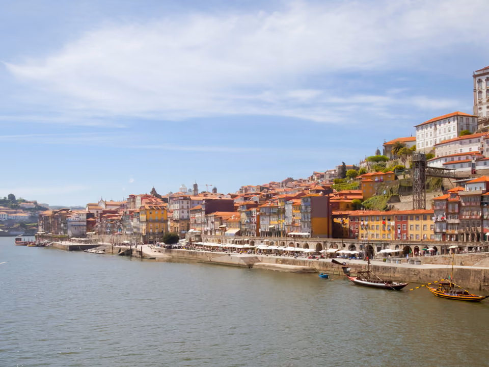 Casas coloridas empilhadas no bairro Ribeira em Porto, à beira do rio Douro, com roupa estendida entre as janelas