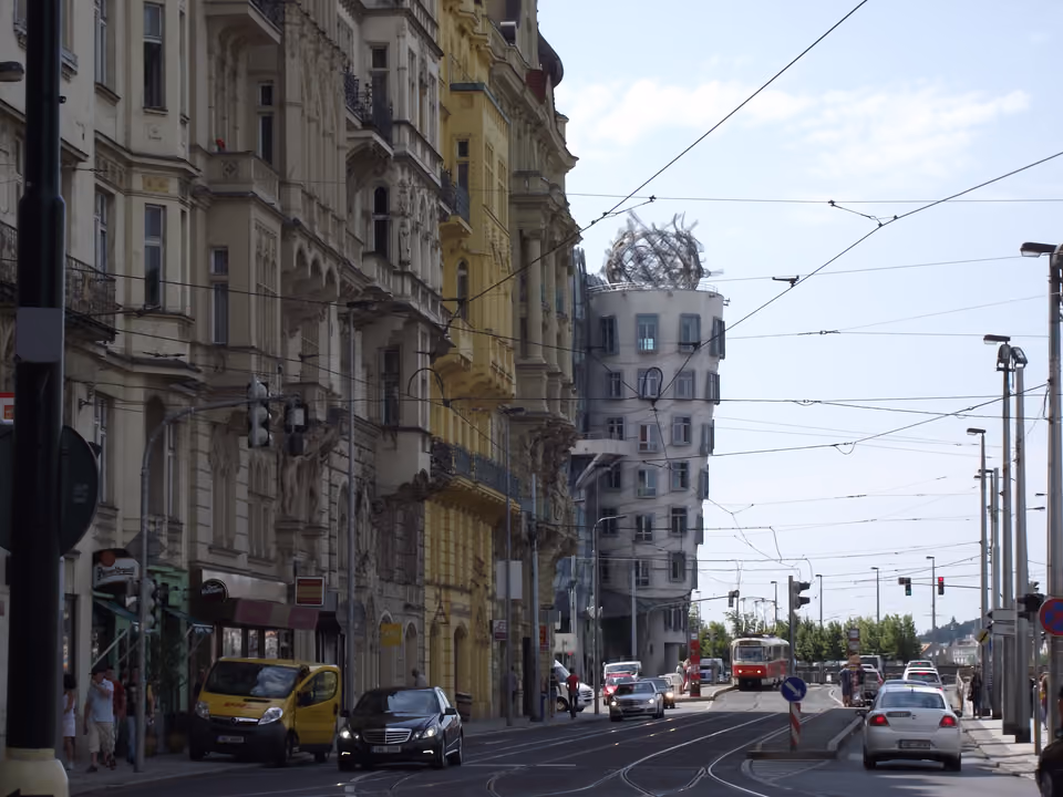 Casa Dançante em Praga vista de uma rua do centro, o prédio moderno de formas onduladas com a escultura metálica no topo