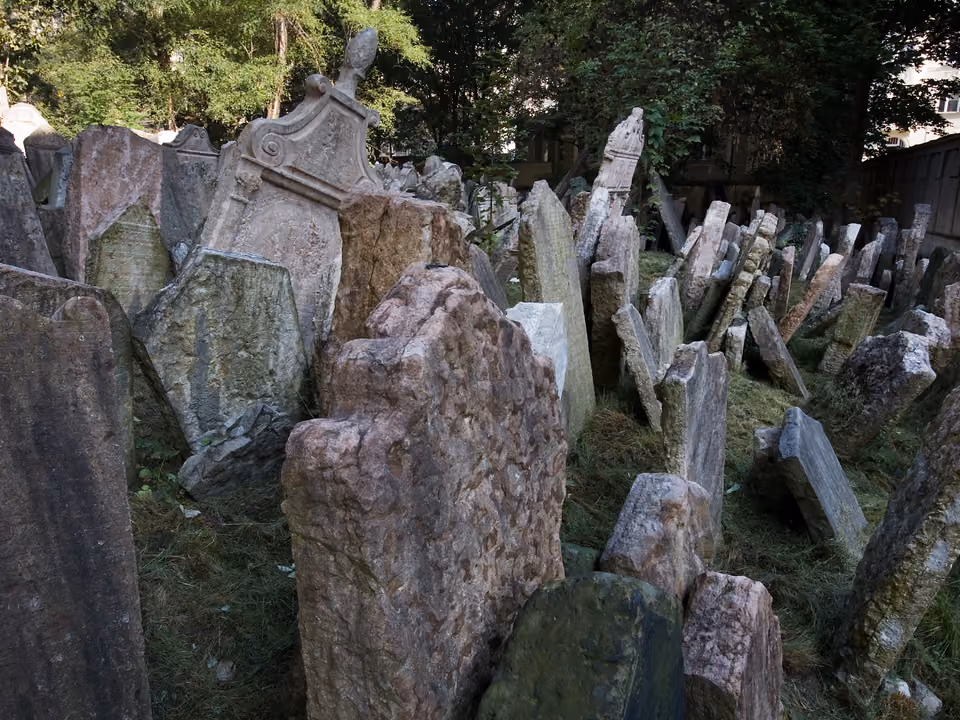 Sinagoga histórica no bairro judeu Josefov em Praga, com o Antigo Cemitério Judeu de lápides inclinadas ao lado