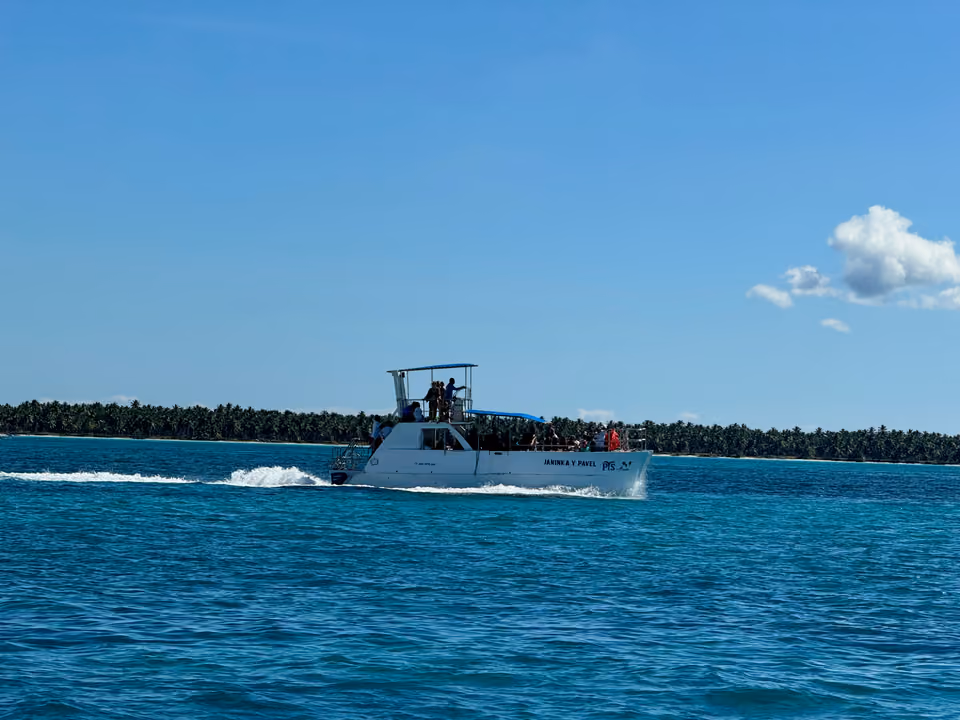 Barco de excursão navegando perto da costa da República Dominicana, com passageiros a bordo