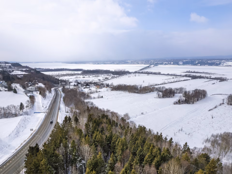 Vista aérea de inverno da Île d'Orléans, perto de Quebec, com estrada e campo coberto de neve