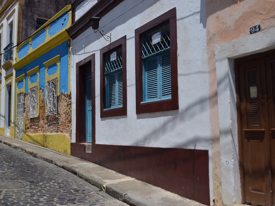 Ladeira colonial de Olinda com casario colorido em azul, amarelo e branco, portas e janelas emolduradas em tons contrastantes