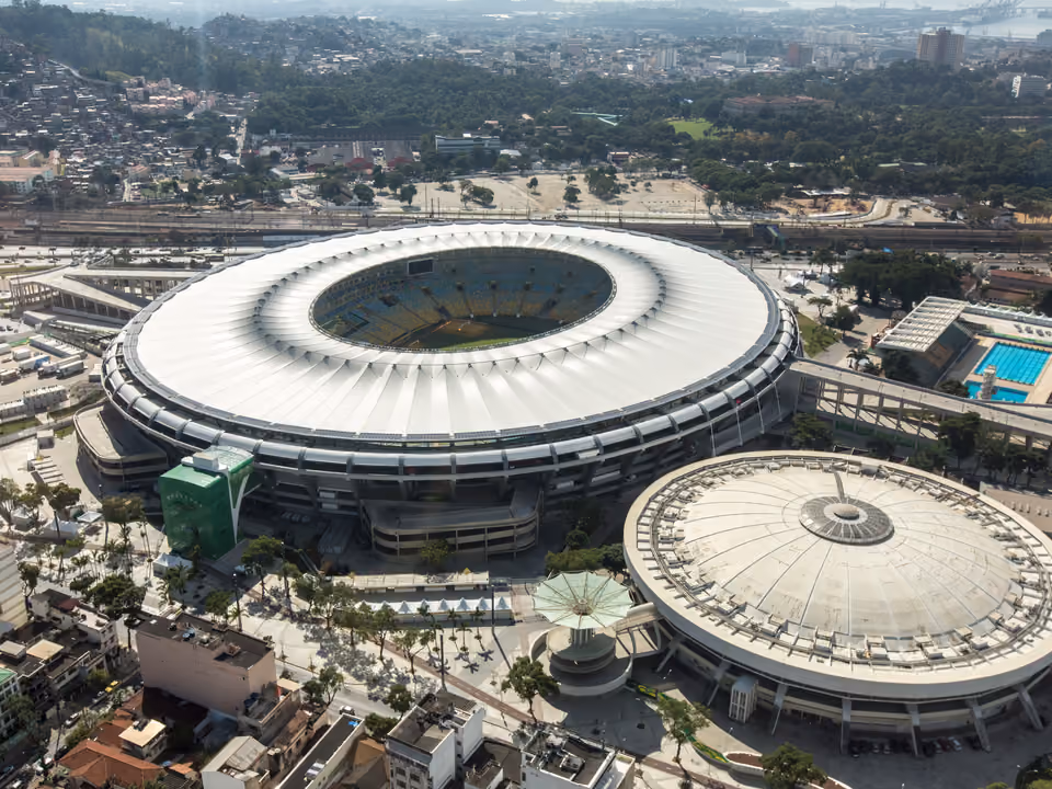 Vista aérea do Estádio do Maracanã no Rio de Janeiro, a arquibancada elíptica com a cobertura branca em anel, e o ginásio Maracanãzinho ao lado