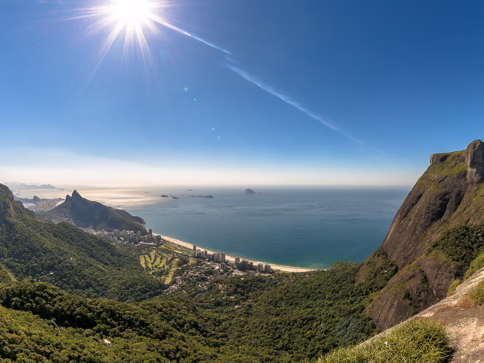 Vista do alto da Pedra Bonita no Rio de Janeiro para a imensa Pedra da Gávea à direita, a praia e o bairro de São Conrado embaixo, a Floresta da Tijuca e o mar aberto