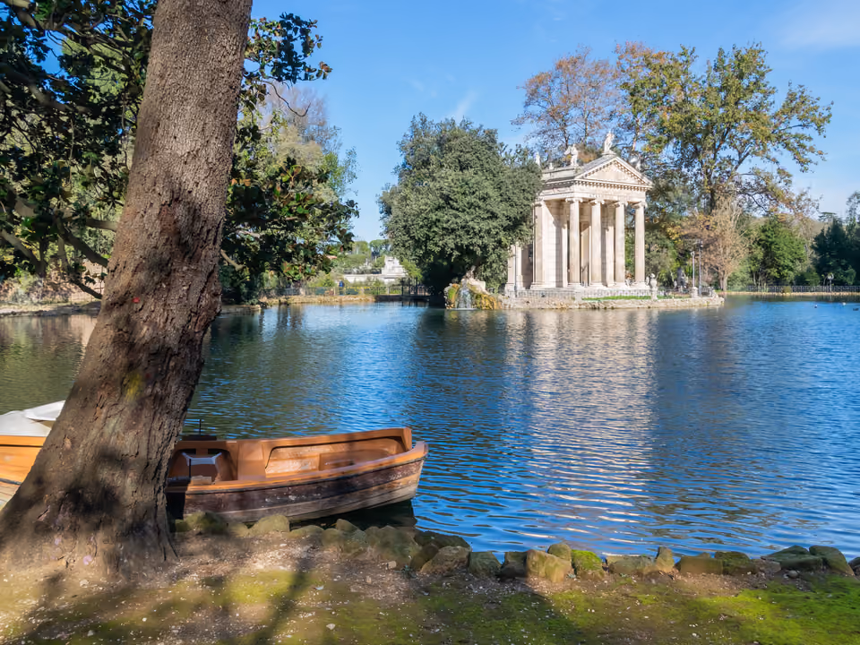 Lago da Villa Borghese em Roma, com o pequeno Templo de Esculápio neoclássico numa ilhota e barcos a remo na margem