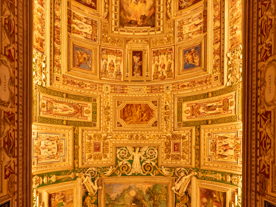 Teto abobadado ricamente decorado de uma das galerias dos Museus do Vaticano, com afrescos emoldurados em estuque dourado