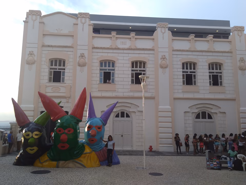Fachada restaurada de 1911 da Casa do Carnaval da Bahia, no Pelourinho em Salvador, com três grandes esculturas de máscaras de carnaval coloridas à frente
