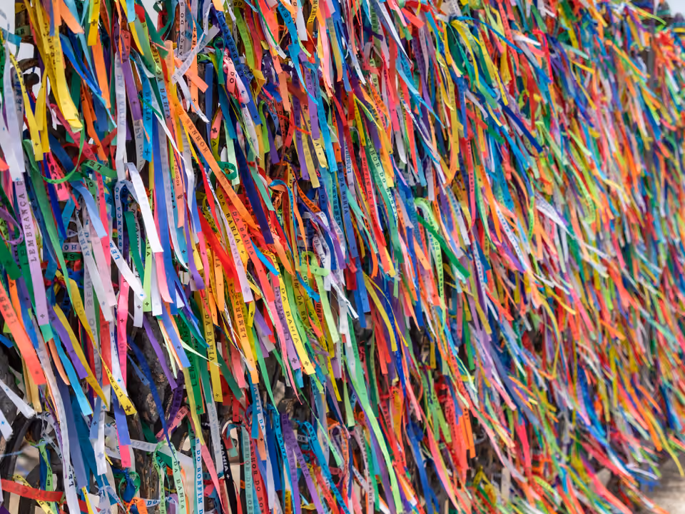 Parede de fitinhas coloridas do Senhor do Bonfim amarradas no gradil da Igreja de Nosso Senhor do Bonfim, em Salvador, preenchendo todo o quadro