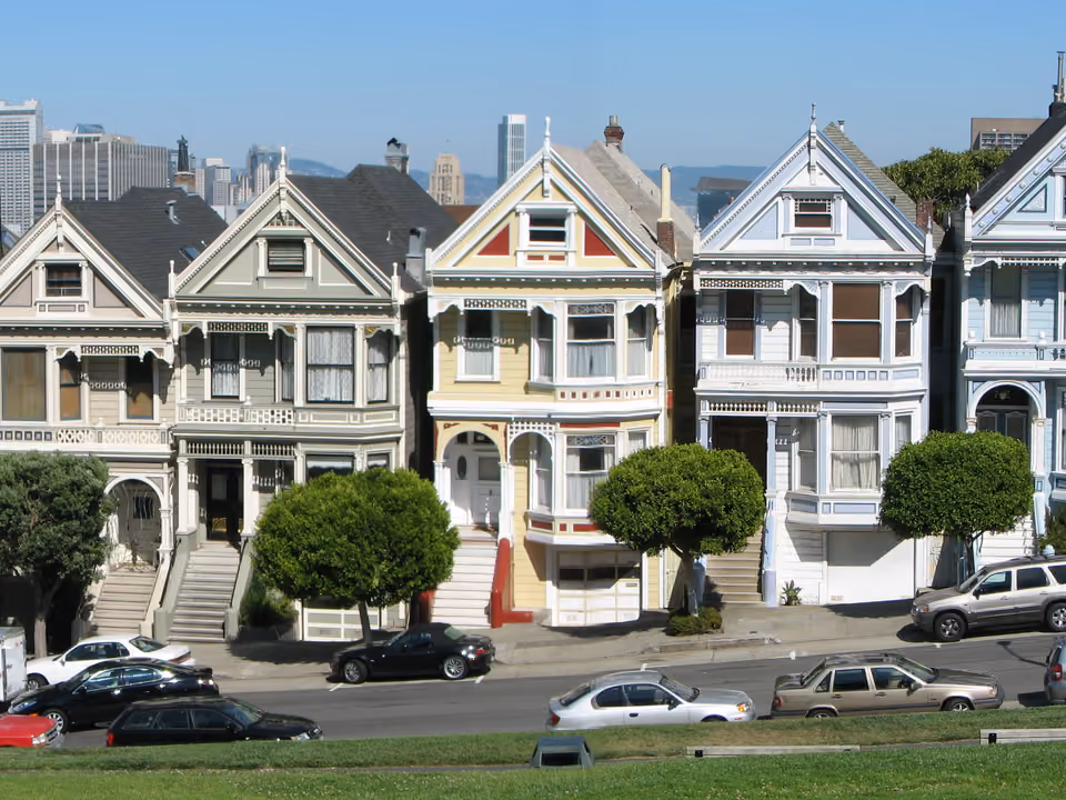 Fileira de casas vitorianas coloridas conhecidas como Painted Ladies, em Alamo Square, San Francisco, com os prédios modernos do centro ao fundo
