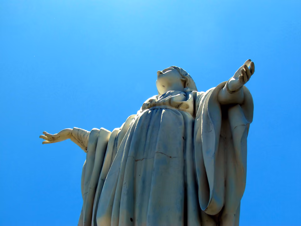 Estátua branca da Virgem da Imaculada Conceição no topo do Cerro San Cristóbal, vista de baixo contra o céu azul