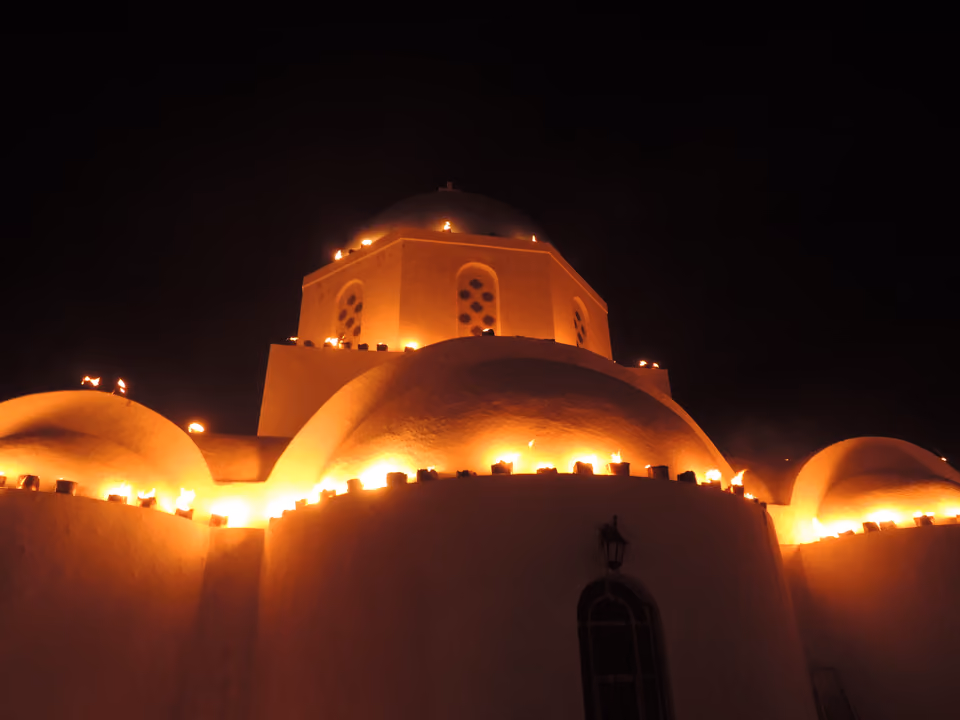 Vila de Pyrgos em Santorini, com casas brancas em ruas estreitas subindo até o castelo medieval no topo