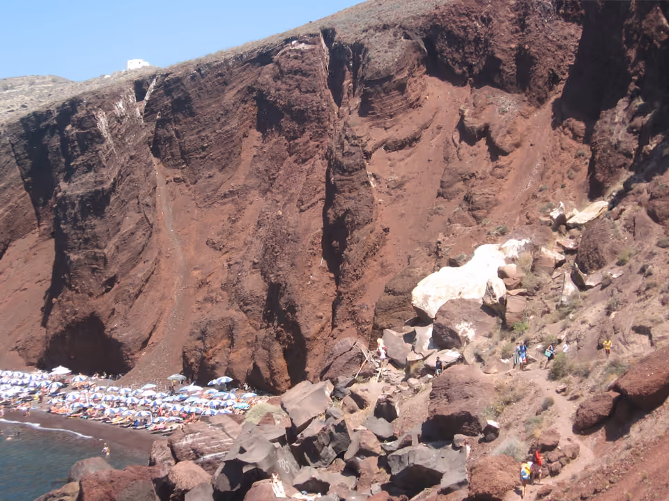 Praia Vermelha (Red Beach) em Santorini, com as falésias de rocha vulcânica avermelhada ao redor da faixa de areia