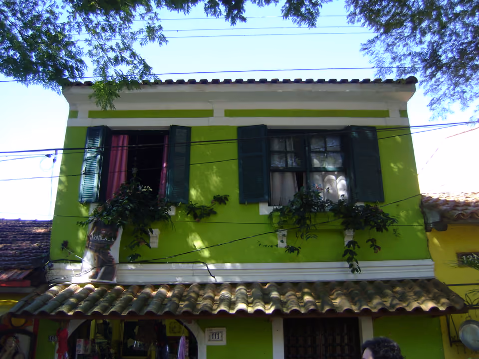 Sobrado colonial de Embu das Artes, na Grande São Paulo, pintado de verde-limão, com janelas de folha, telhado de barro e um ateliê de artesanato no térreo