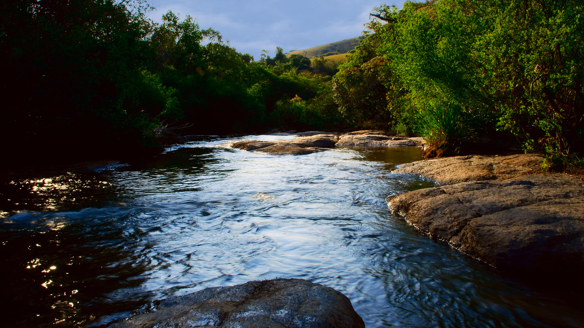 Trecho de rio entre rochas e morros verdes, em Socorro, no Circuito das Águas Paulista