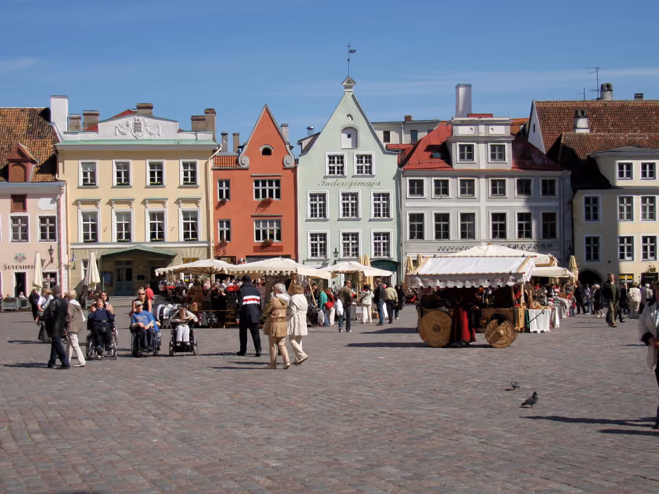 Praça da Prefeitura de Tallinn (Raekoja Plats), com fachadas coloridas e barraca tradicional, Estônia