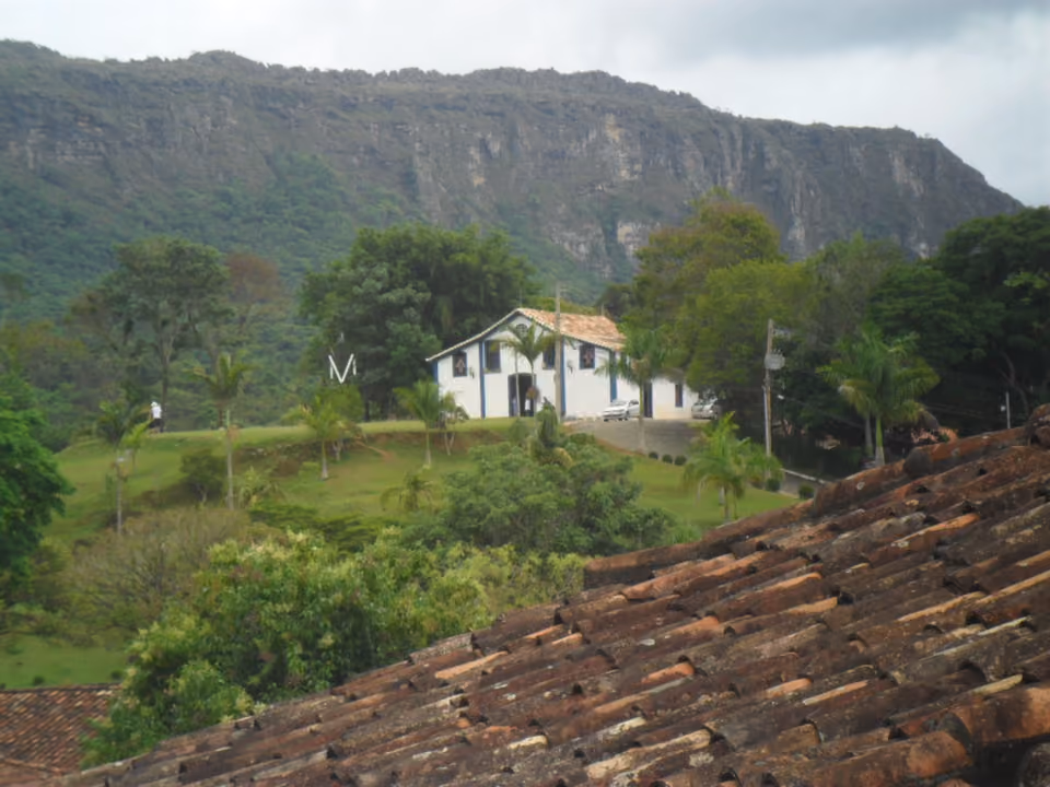 Casa colonial em meio à vegetação, com a Serra de São José ao fundo, em Tiradentes