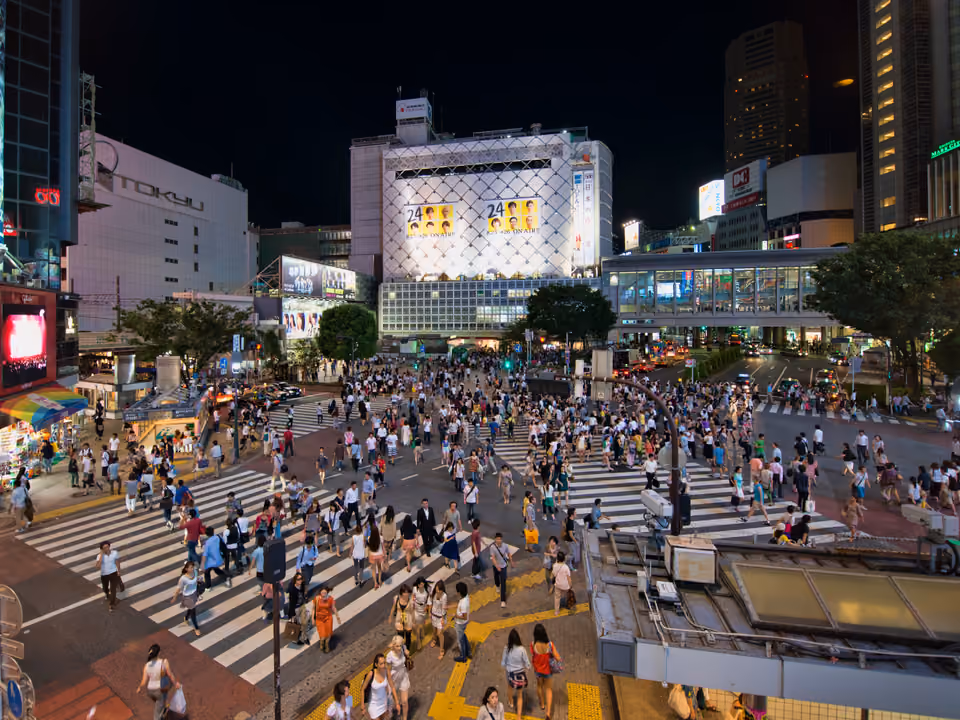 Travessia de pedestres de Shibuya Crossing, em Tóquio, cheia de gente sob os telões luminosos