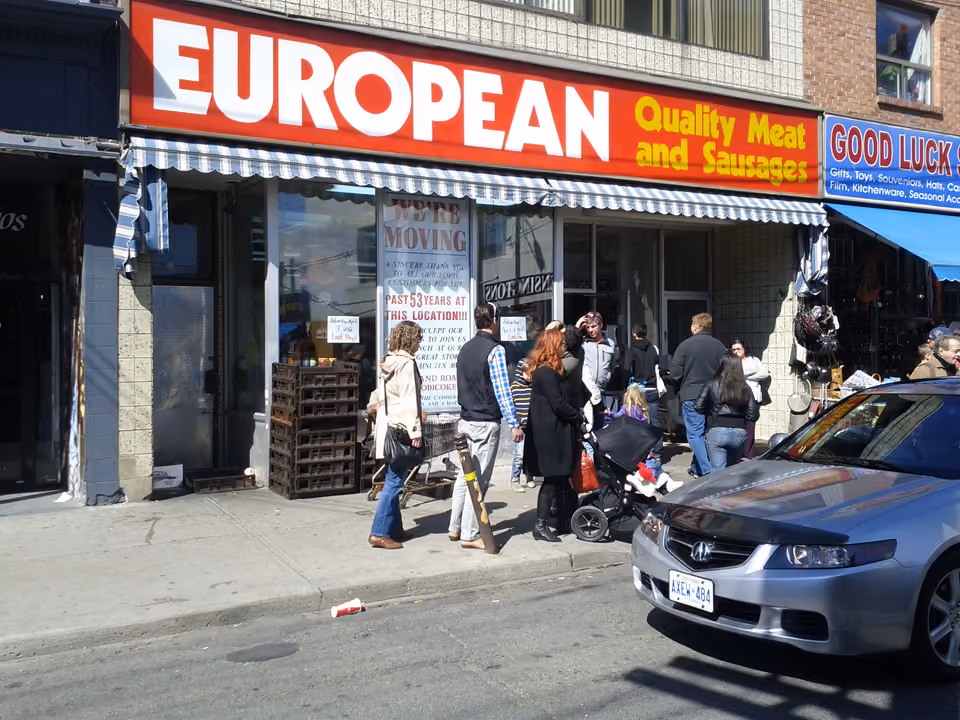 Rua colorida do bairro Kensington Market em Toronto, com fachadas pintadas e lojas de rua movimentadas