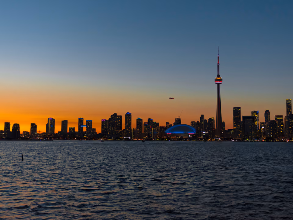 Praia e trilha nas Toronto Islands, com o horizonte de arranha-céus da cidade visível do outro lado da água