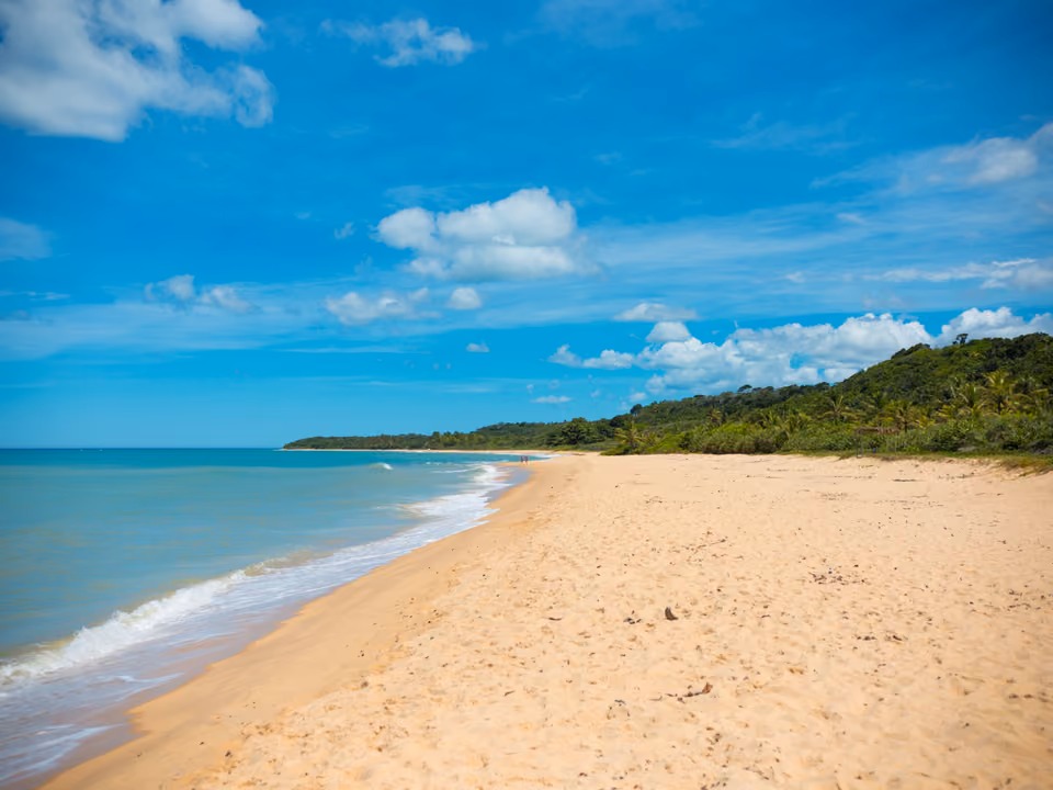 Praia de Itapororoca com falésias coloridas e vegetação de restinga ao fundo