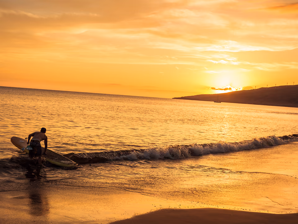 Pessoa praticando stand up paddle ao entardecer, imagem ilustrativa — não fotografada no Rio Trancoso