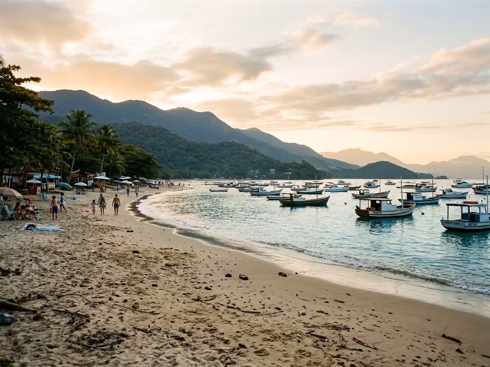 Mar manso e claro da Praia do Lázaro com barcos ancorados na enseada
