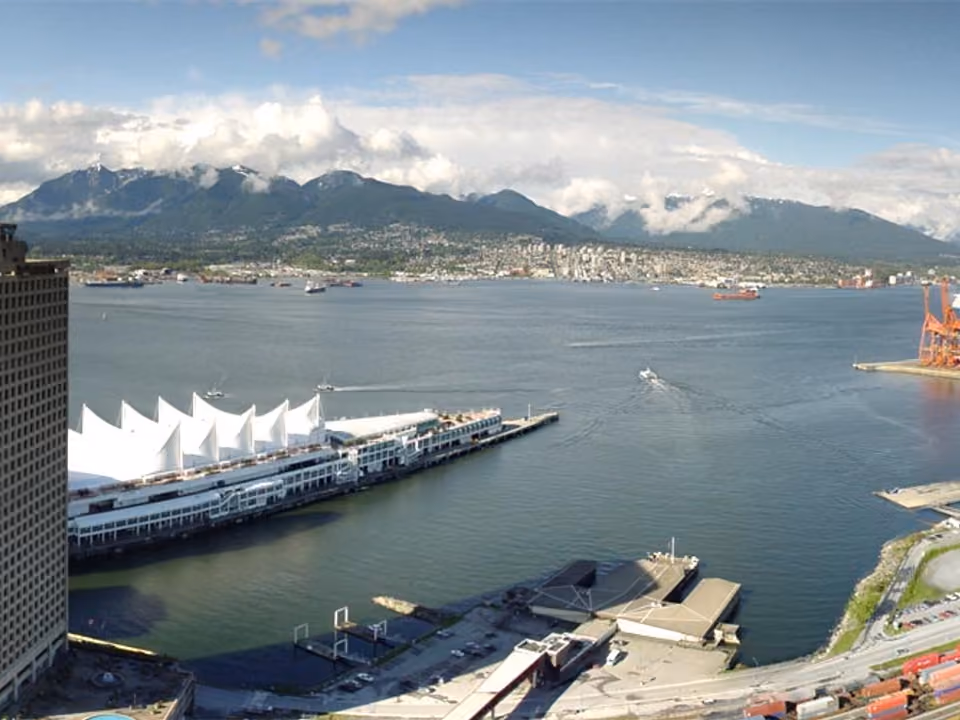 Vista panorâmica do topo da torre Harbour Centre em Vancouver, com o Canada Place, o porto e as montanhas ao fundo