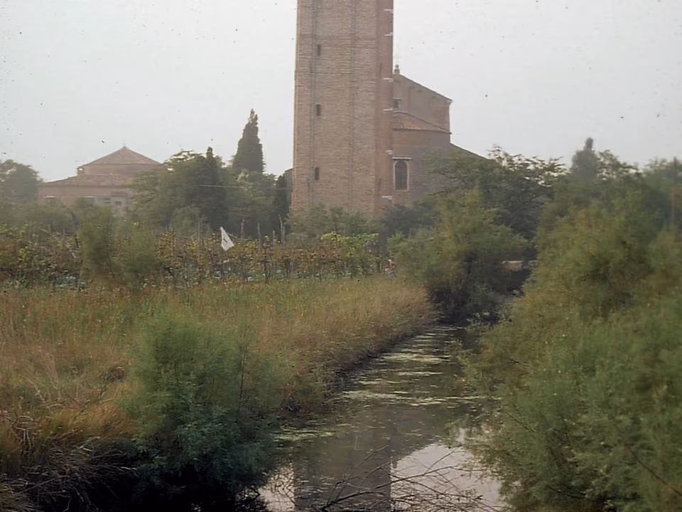 Basílica de Torcello na ilha de Torcello, perto de Veneza, com os campos abertos e poucas construções ao redor