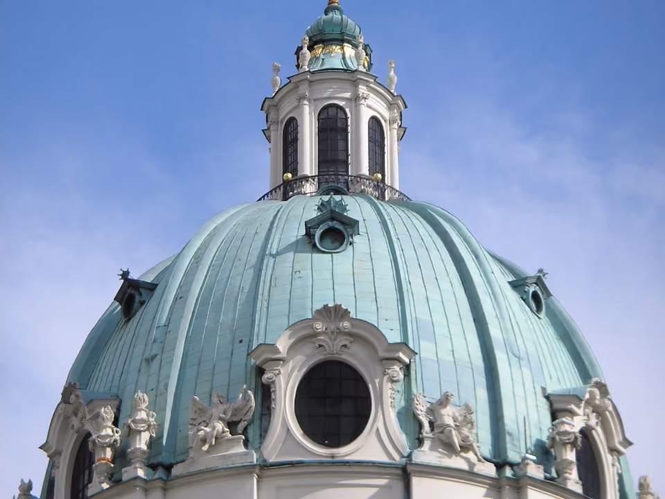 Igreja Karlskirche em Viena, com a cúpula verde barroca e as duas colunas esculpidas na fachada