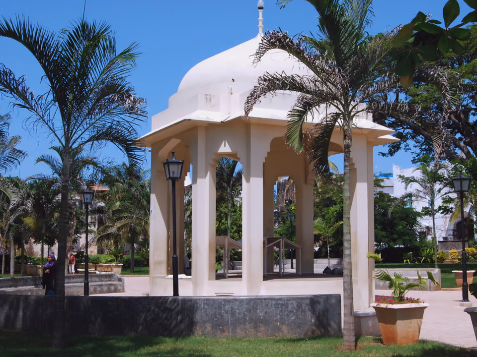 Pavilhão histórico entre palmeiras em jardim de Stone Town, Zanzibar